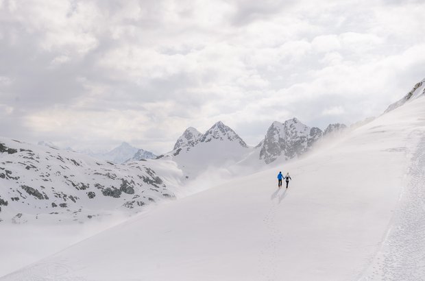 Mann und Frau machen eine Winterwanderung mit traumhaften Bergpanorama.
