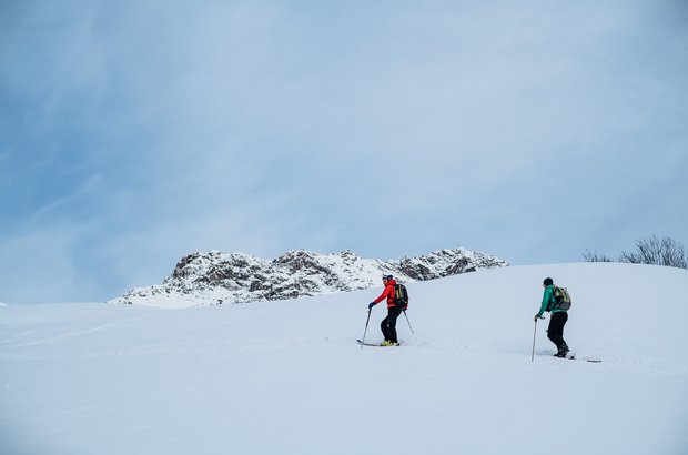 Zwei Skitourengeher sin auf dem Weg den Gipfel zu erklimmen.
