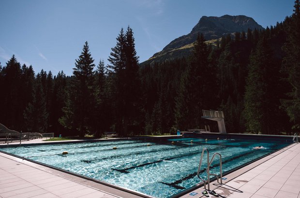 Waldschwimmbad in Lech mit Bergausblick.