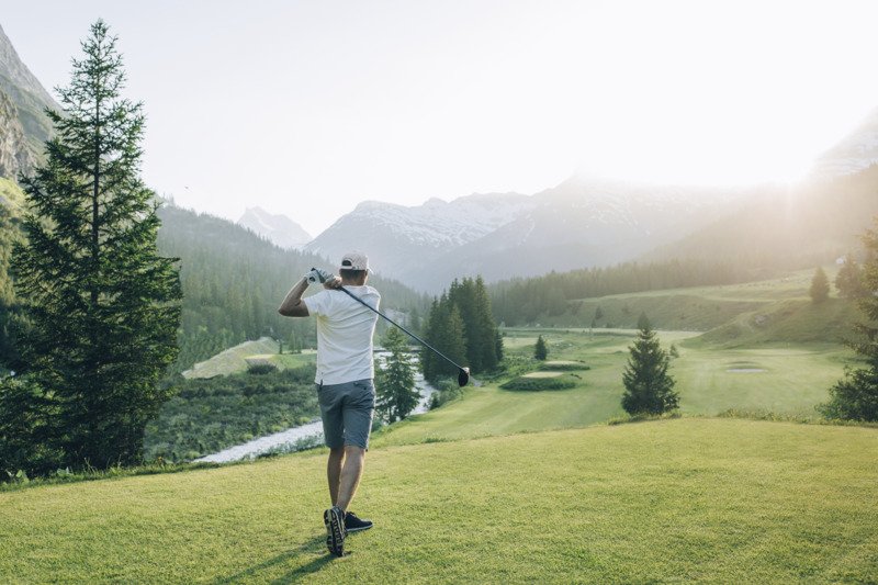 Golfer schlägt den Golfball über den Rasen.