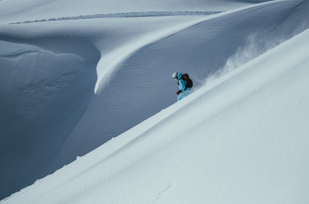 Skifahrer genießt die Abfahrt übe die weiße Landschaft. 