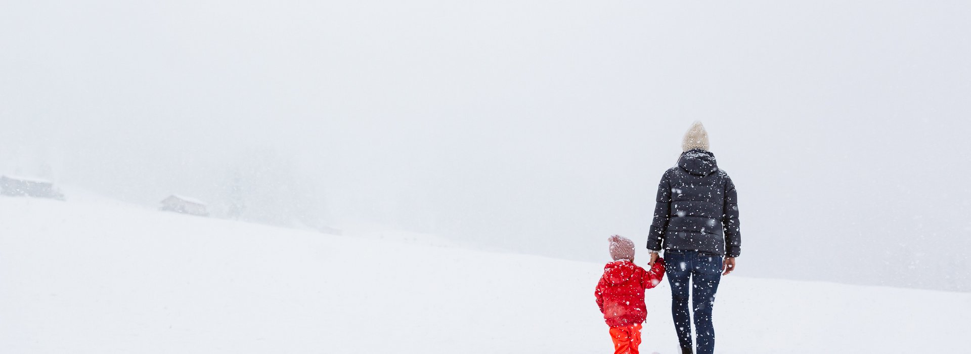 Frau und Kind spazieren im Schnee