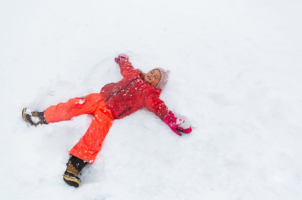 Kind macht einen Schneeengel