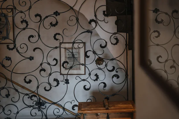 Schwarzes schmiedeeisernes Treppengeländer mit Holztruhe davor