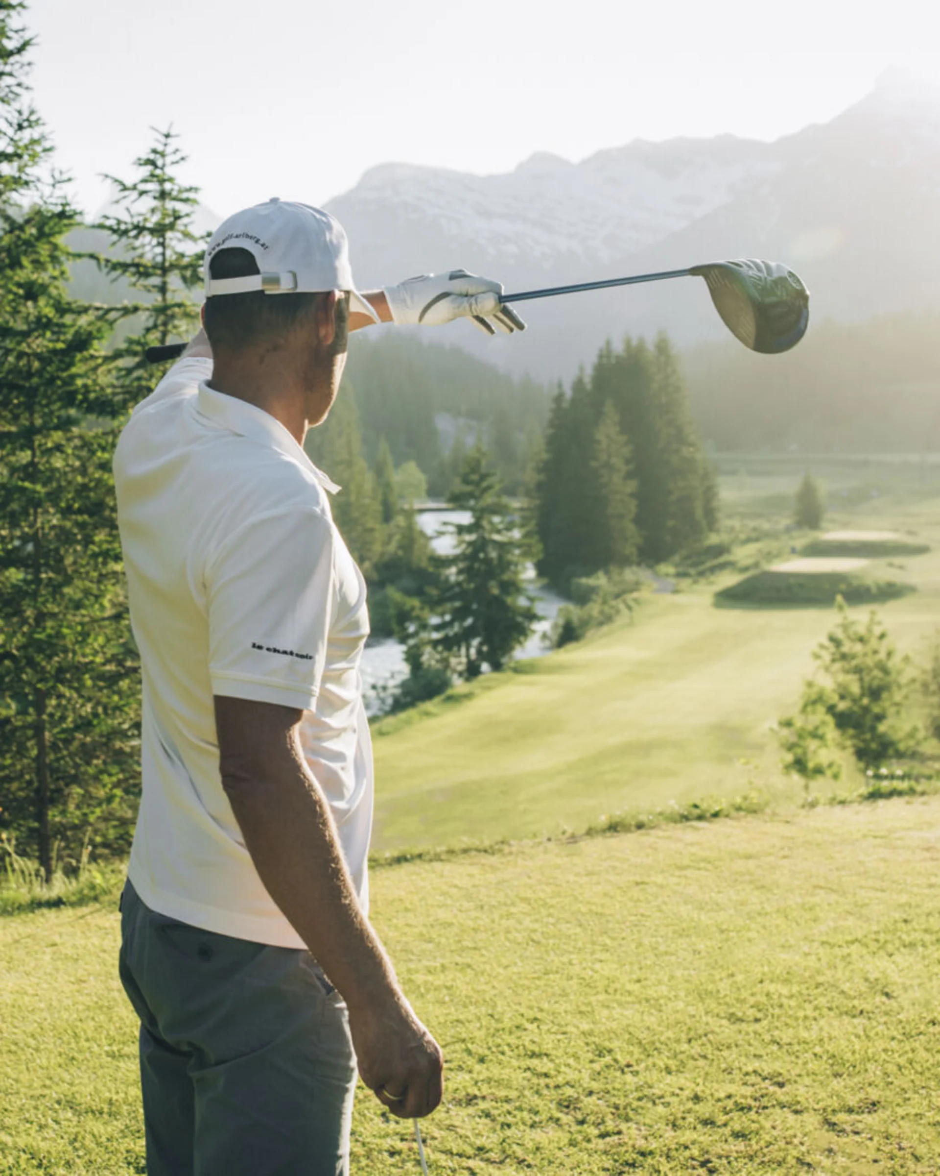 Golfspieler auf einem Berggolfplatz mit Alpenpanorama