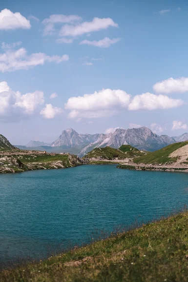 Hotel Aurora: der perfekte Ausgangspunkt für einen Fischerausflug am Lechbach Bergsee mit grünen Ufern und schroffen Bergen unter blauem Himmel