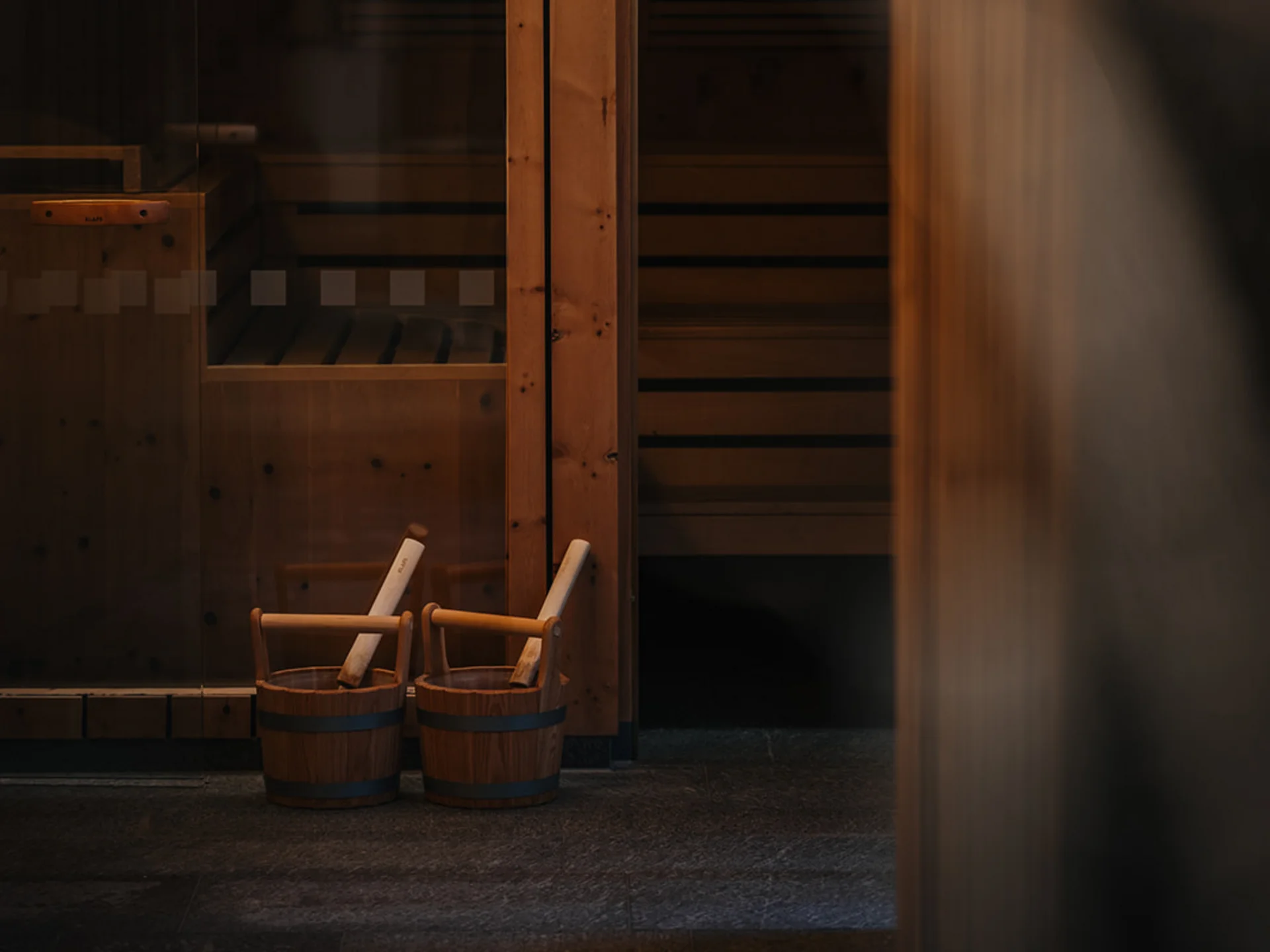 Interior of a sauna with wooden walls and two wooden buckets
