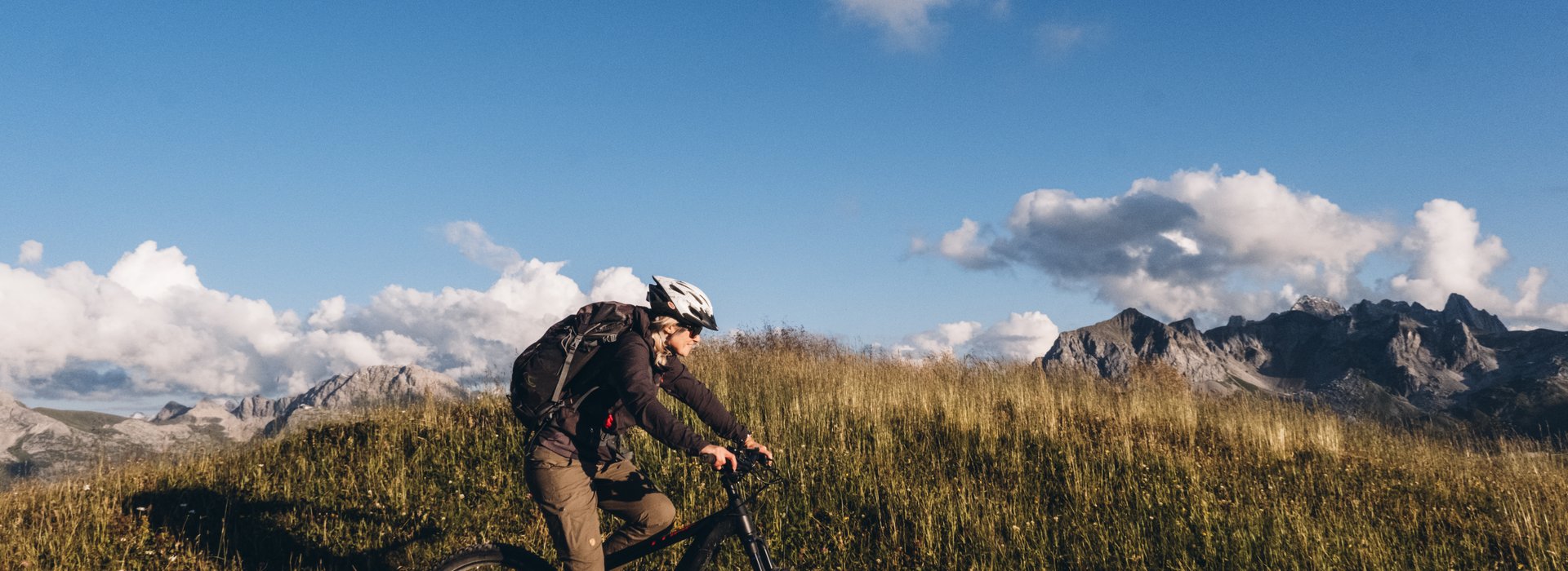 Mountainbikerin fährt über die Almwiesen.