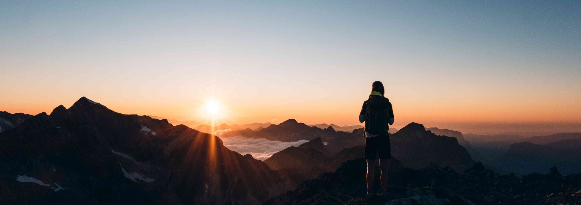 Wanderer am Berg bei Sonnenaufgang