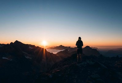 Wanderer am Berg bei Sonnenaufgang