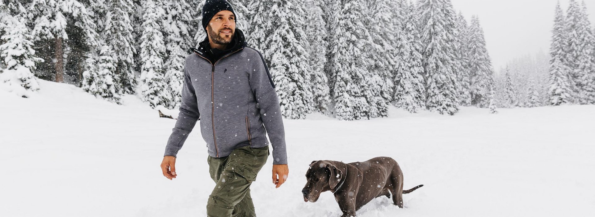 Mann mit Hund in Winterlandschaft