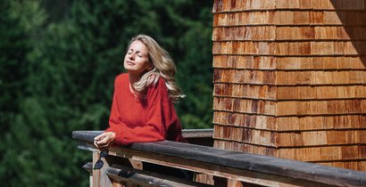 Frau genießt die Sonne am Balkon