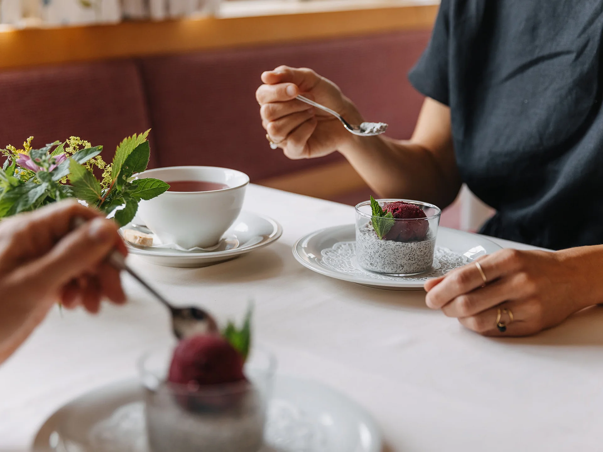 Two people eating dessert and drinking tea at a set table