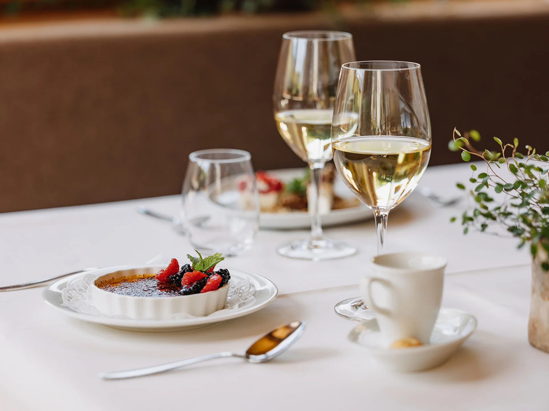 Creme Brulee with berries and sparkling wine glasses on a set table