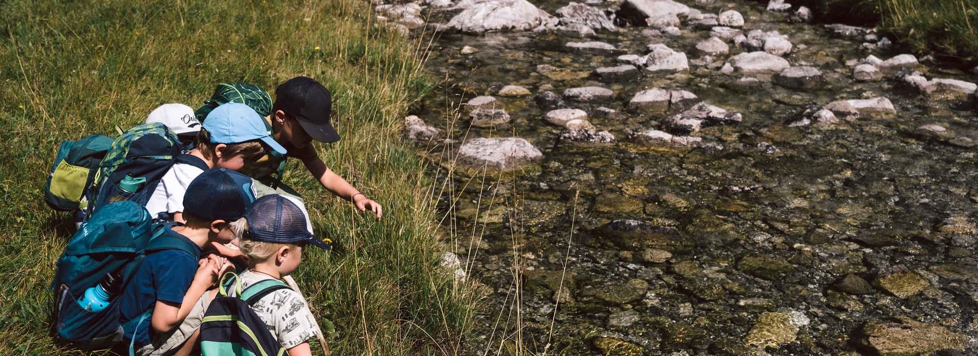 Kinder sitzen am Ufer des Lechs