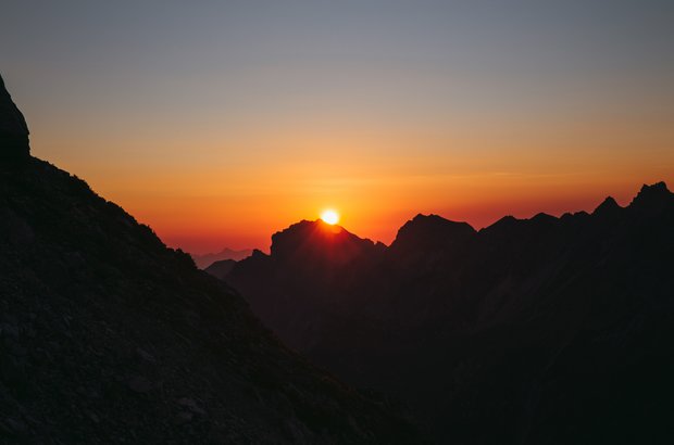 Sonnenuntergang mit einem Bergpanorama.