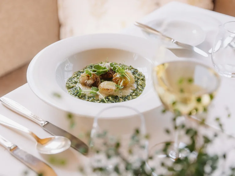 Elegantes Gericht mit Jakobsmuscheln auf cremigem Spinatrisotto mit Schaum