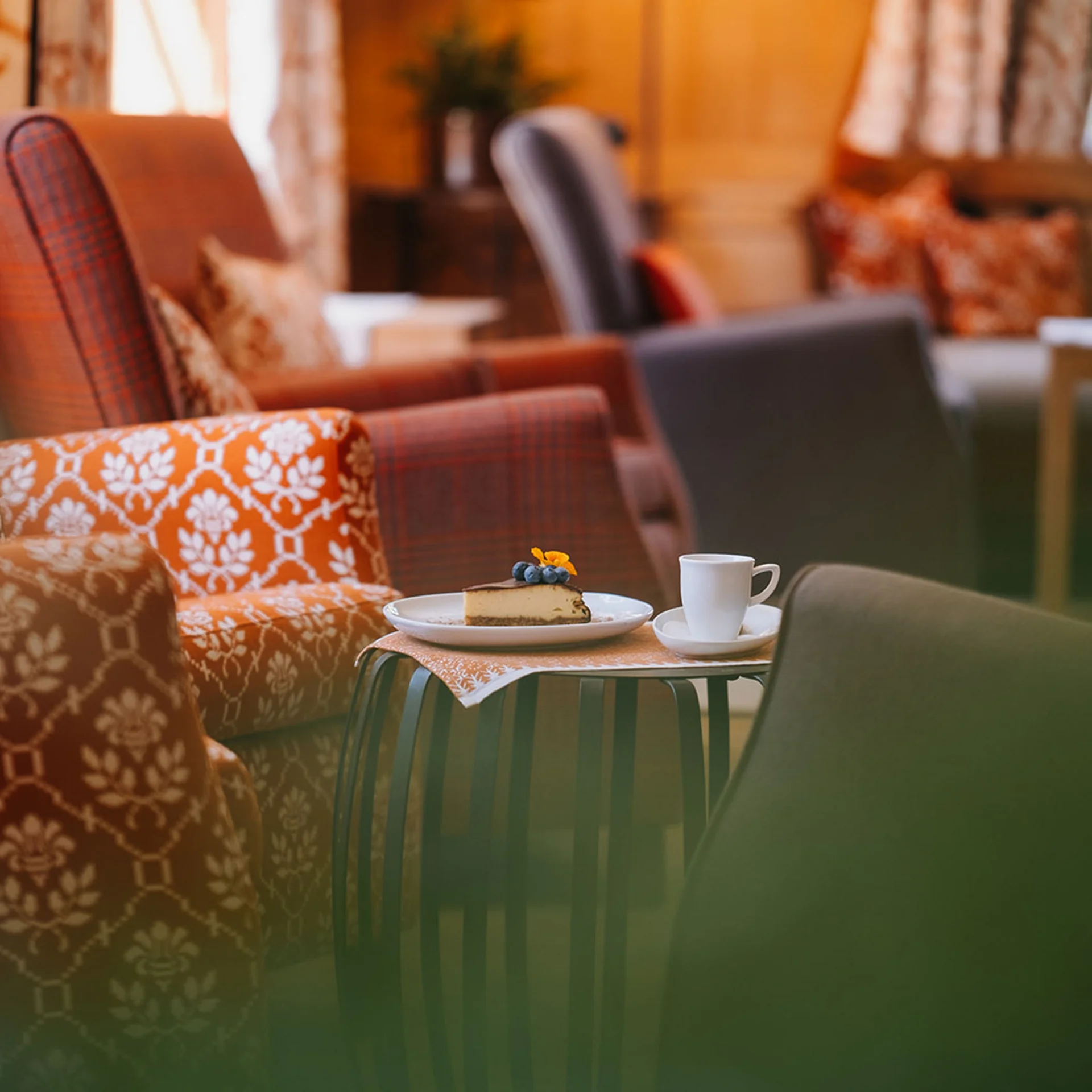 Gemütliche Sessel mit einem Tisch und Kuchen und Kaffee in einem Wohnzimmer