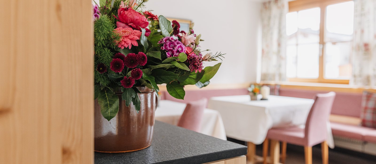 Blick in den Frühstücksraum mit Blumenstrauß