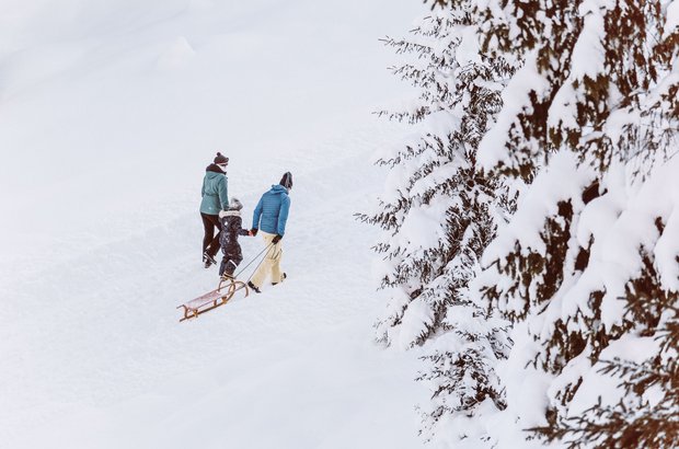 Winterwandern in Lech Familie beim Rodeln