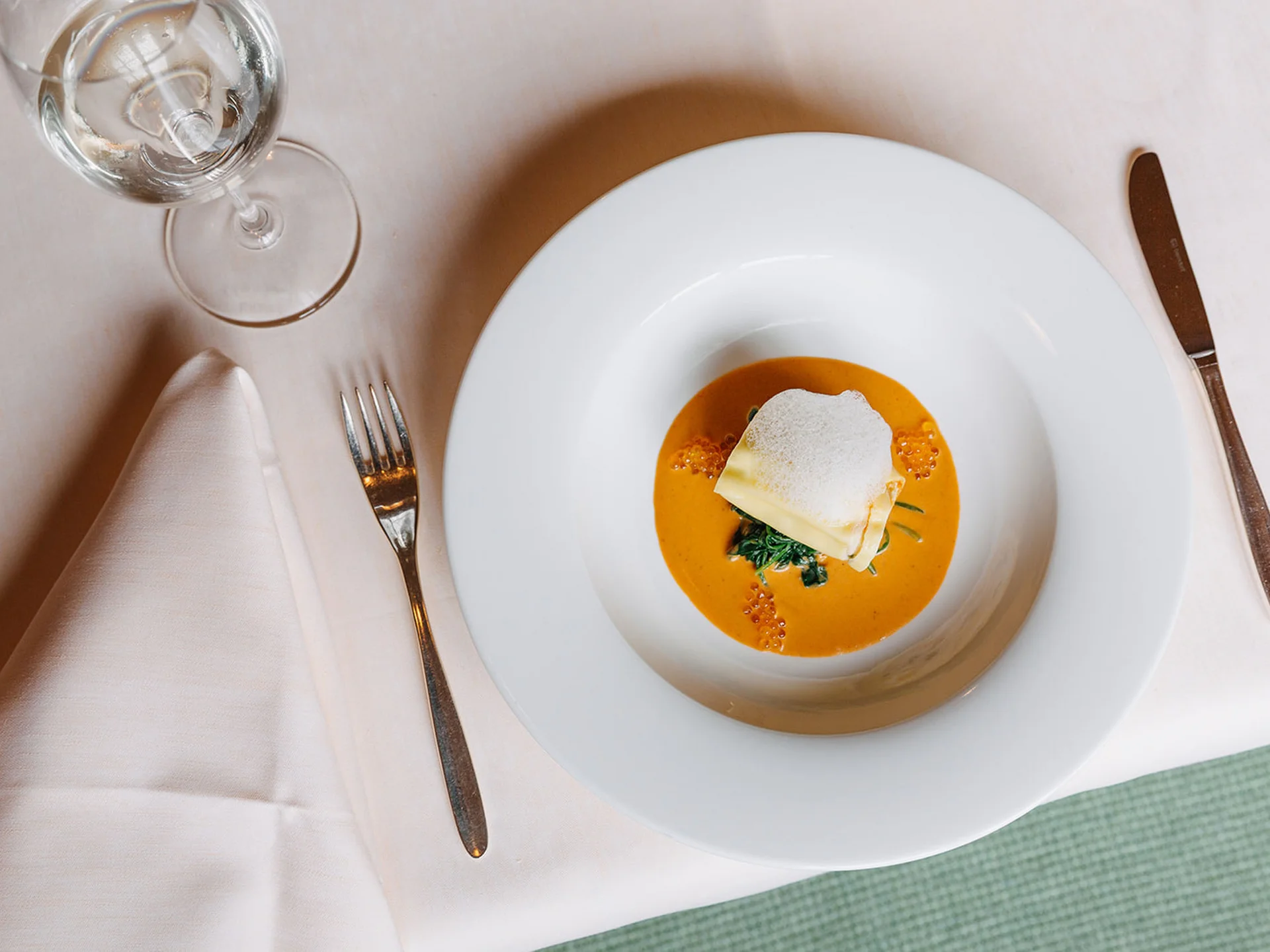 Fine dining gourmet dish with sauce and foam in a white bowl