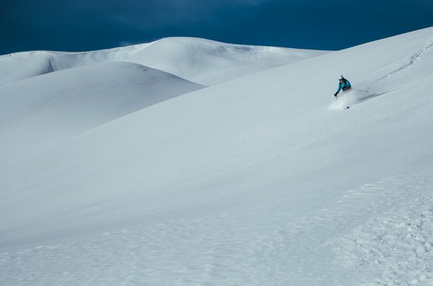 Frau fährt im Tiefschnee 