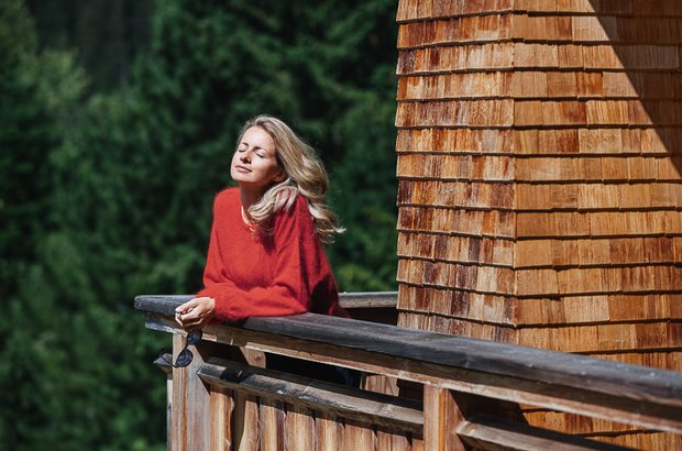 Frau genießt die Sonne am Balkon