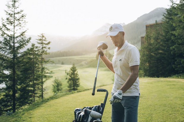 Golfer räumt seinen Golfschläger wieder in den Trolley