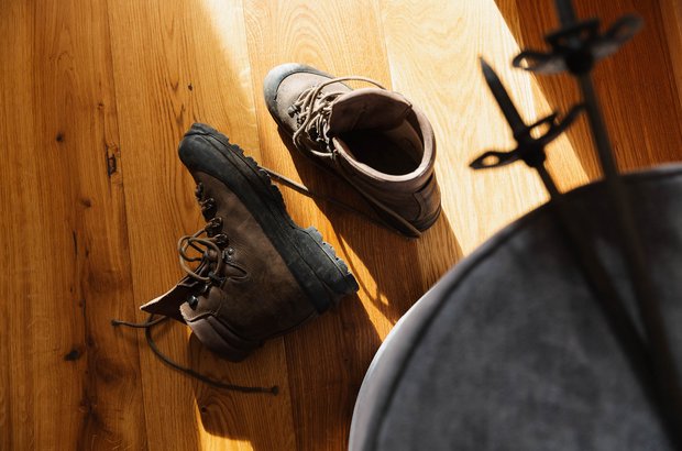 Wanderschuhe liegen am Holzboden