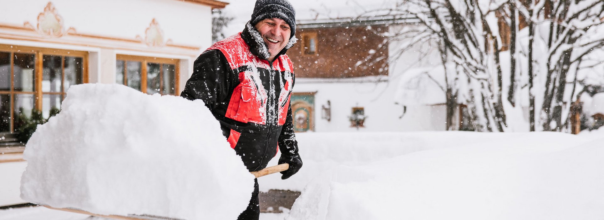 Mann ist am Schnee schippen