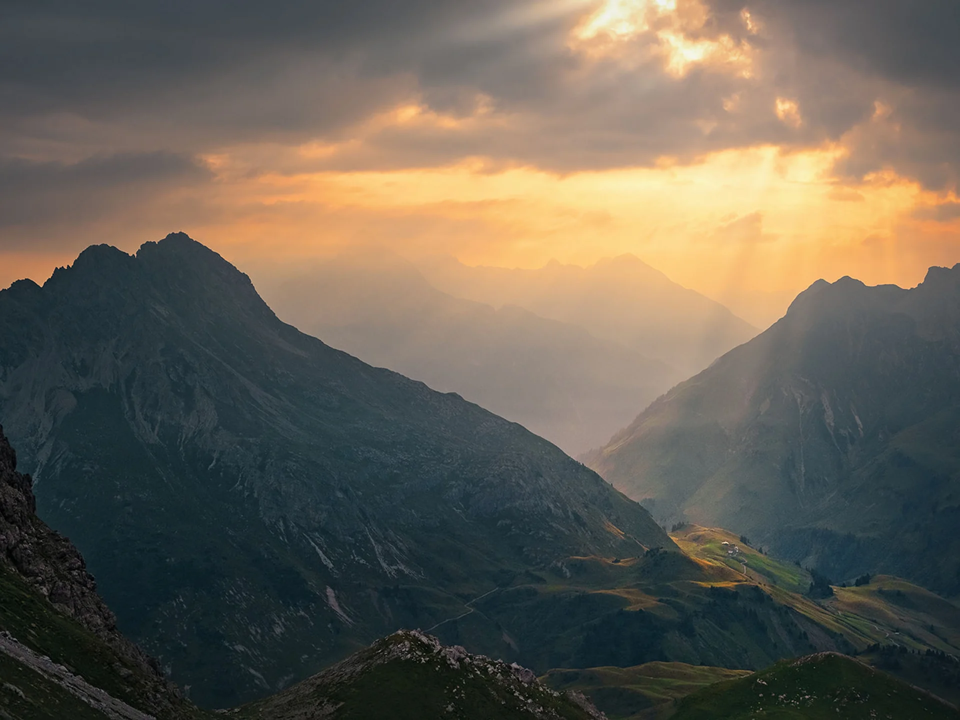 Dramatic mountain landscape with sun rays breaking through clouds
