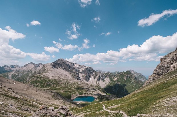 Ausblick auf den Butzensee mit einer schroffen Berglandschaft im Hintergrund.