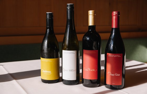 Vier Weinflaschen stehen auf einem Tisch.