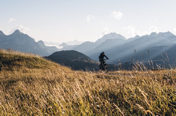 Bikerin auf dem Fahrradweg mit traumhaftem Bergpanorama.