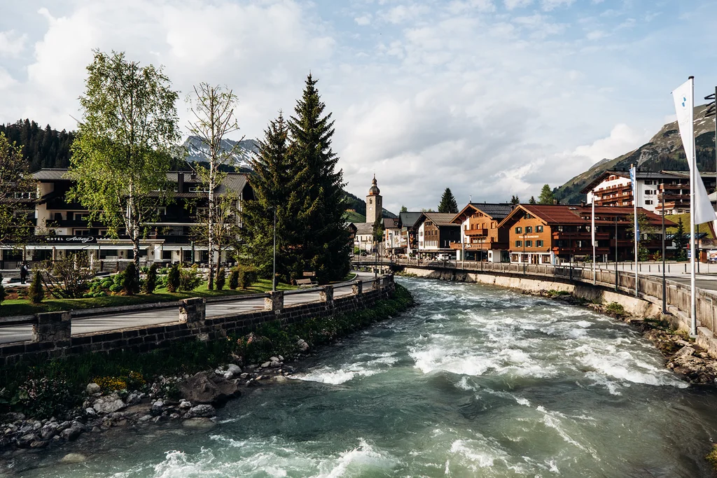 Hotel Aurora: der perfekte Ausgangspunkt für einen Fischerausflug am Lechbach Alpendorf mit Kirche und rauschendem Fluss vor bewaldeten Bergen