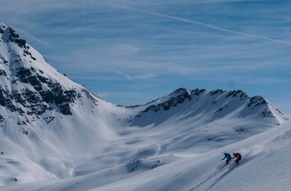 Eine Person fährt mit Skiern den Hang hinunter