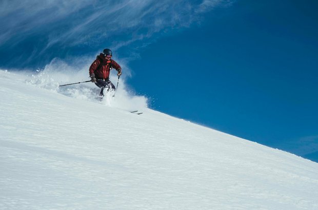 Ein Skifahrer fährt durch den Pulverschnee