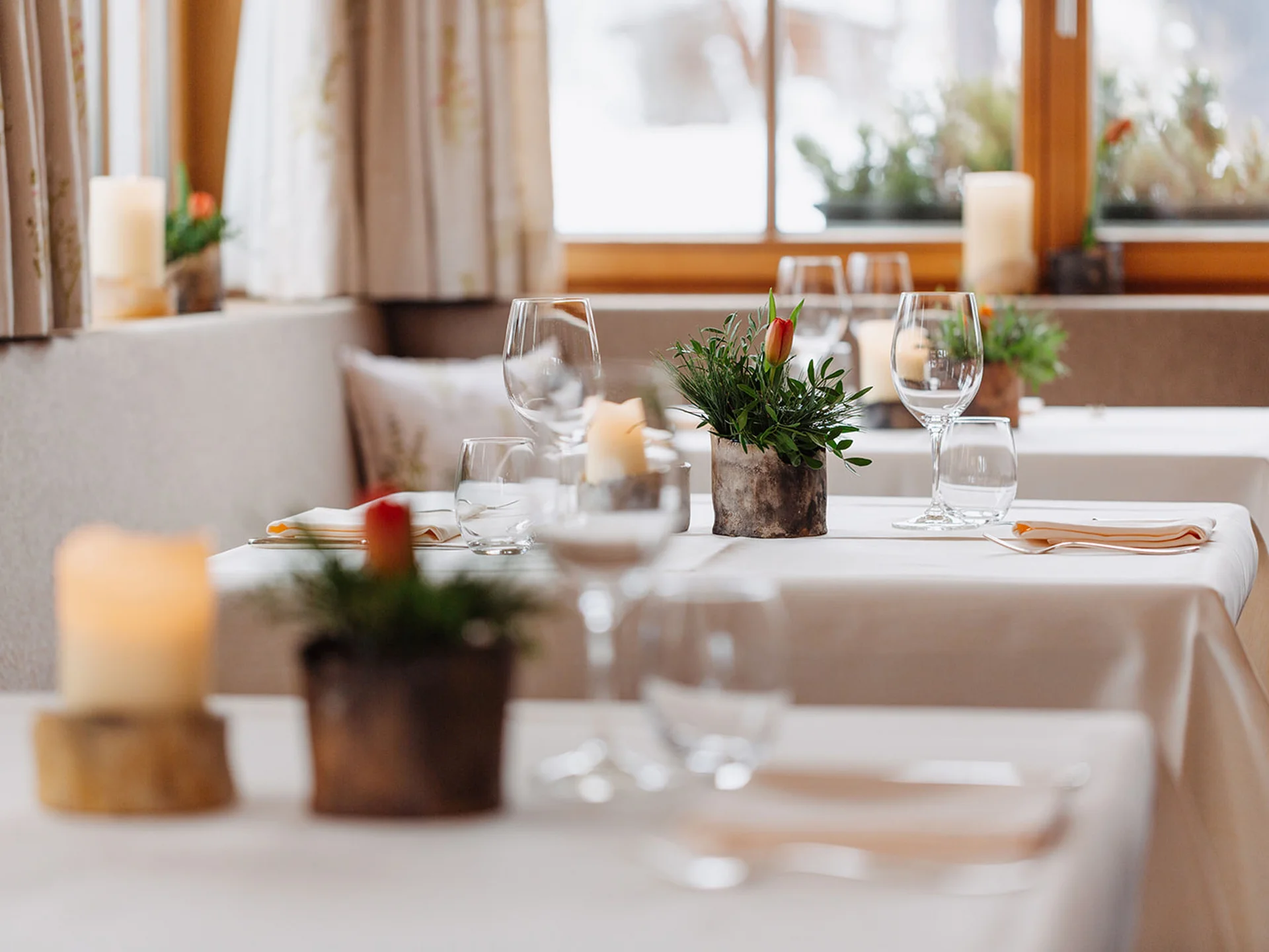 White set tables with glasses and flowers in a bright restaurant