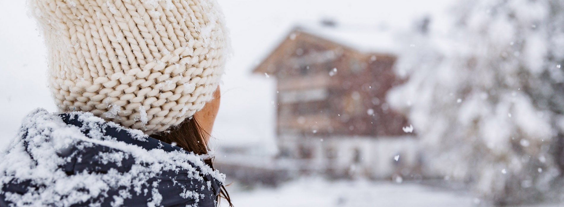 Frau vor Haus Braunarl im Winter