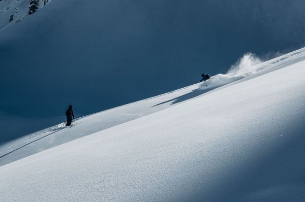 Skifahrer fährt Freeride auf frischem Schnee.