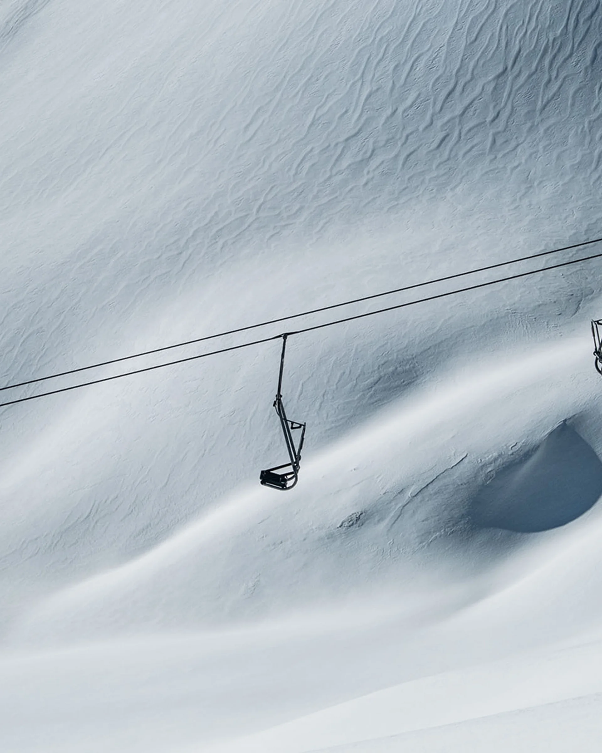 Leere Skilifte über verschneitem, bergigem Terrain