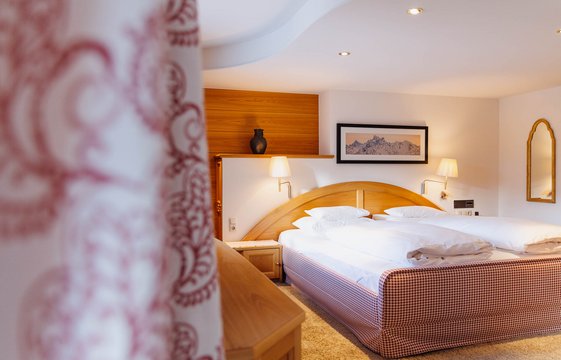 Schlafzimmer Komfortdoppelzimmer mit Balkon mit Vorhang im Vordergrund Ansicht des Schlafzimmers im Komfortdoppelzimmer mit Balkon mit Vorhang im Vordergrund