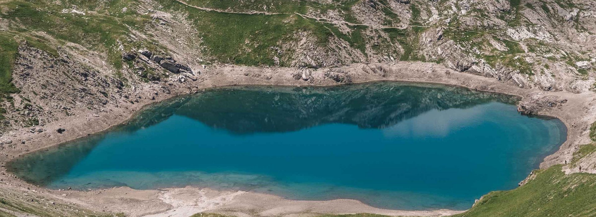 Ein See eingebettet in mitten der Berglandschaft. 