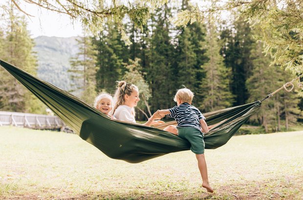 Frau mit Kindern in Hängematte