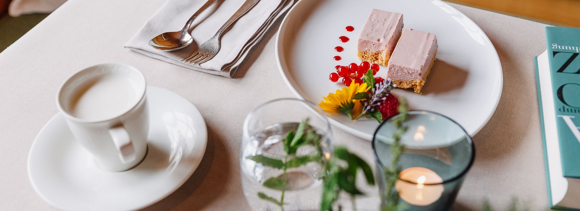 Schön gedeckter tisch mit einer Tasse Kaffee und einer Erdbeersahneschnitte. 