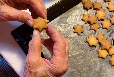 Zwei Hände halten einen Weihnachtskeks