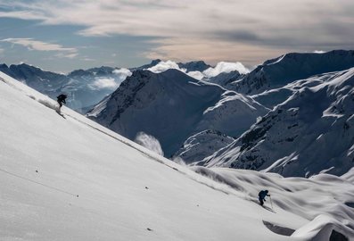 Ein Skifahrer fährt im Tiefschnee den Berg hinunter 