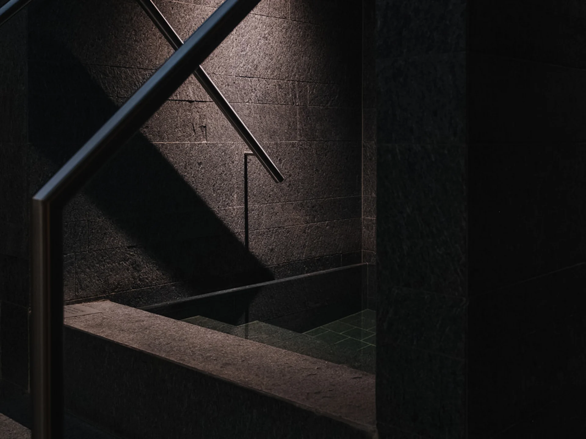 Dark area with stone steps and metal handrail