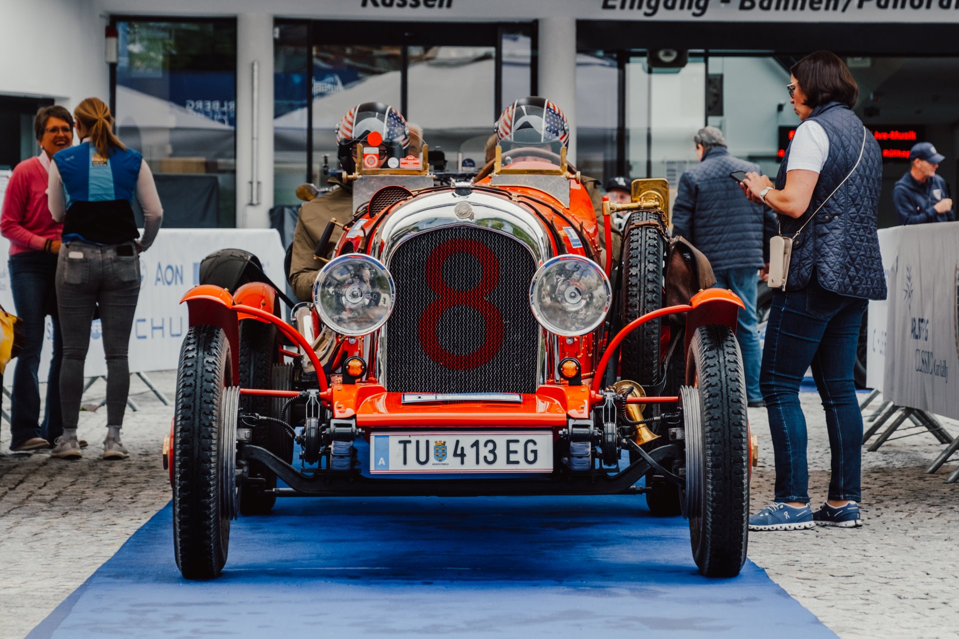 Rotes Oldtimerauto mit Personen