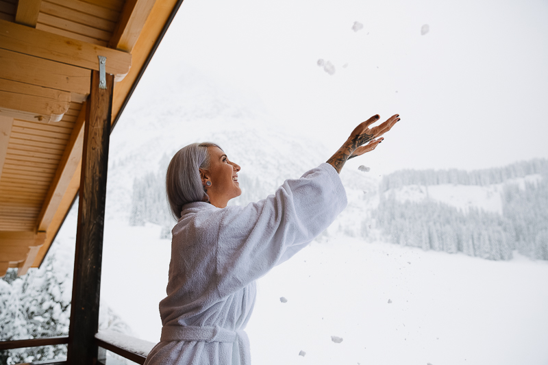 Frau im Bademantel auf Balkon